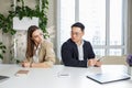 Man and woman sitting in office, holding money at hands. Gender pay gap, unequal salary concept