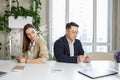 Man and woman sitting in office, holding money at hands. Gender pay gap, unequal salary concept Royalty Free Stock Photo
