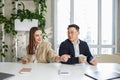 Man and woman sitting in office, holding money at hands. Gender pay gap, unequal salary concept Royalty Free Stock Photo