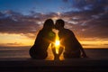 Man and woman sitting by the sea kiss at sunset