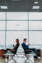 Man and woman are spending time in airport lounge