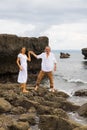 Man and woman spending time together on the beach. Couple walking barefoot on stones near the ocean. Romantic relation between Royalty Free Stock Photo