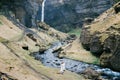 Man and woman stand on the banks of a river in the mountains near a waterfall. Iceland Royalty Free Stock Photo