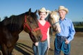 Man and Woman Stand With Horses - horizontal