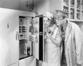 Man and woman standing in front of a refrigerator Royalty Free Stock Photo