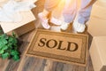 Man and Woman Standing Near Sold Welcome Mat, Moving Boxes