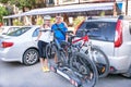 Man and woman are standing near two bicycles mounted on trunk of Royalty Free Stock Photo