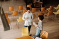 Man and woman students holding books and talking while studying in library Royalty Free Stock Photo