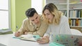 Man and woman students studying together using smartphone at library university Royalty Free Stock Photo
