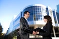 Man and woman in suits shake hands