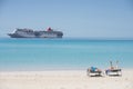 Man and Woman Sunbathing on Beach with Carnival Elation in Background