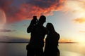 Man and woman at sunset makes a photo