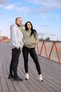 A man and a woman in sweatshirts stand on a bridge getting ready for their morning run Royalty Free Stock Photo