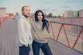 A man and a woman in sweatshirts stand on a bridge getting ready for their morning run Royalty Free Stock Photo