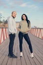 A man and a woman in sweatshirts stand on a bridge getting ready for their morning run Royalty Free Stock Photo