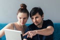 Man and woman with a tablet. Caucasian couple looking at something on the laptop with interest and pointing at the Royalty Free Stock Photo