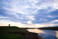 A man and a woman talk at sunset at the banks of the river Royalty Free Stock Photo