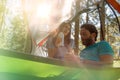 Man and woman talking in hanging tent camping in forest woods during sunny day.Group of friends people summer adventure Royalty Free Stock Photo