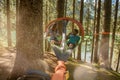 Man and woman talking in hanging tent camping in lake forest woods during sunny day.Group of friends people summer Royalty Free Stock Photo