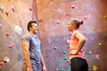Man and woman talking at indoor climbing gym wall Royalty Free Stock Photo
