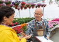 Man and woman talking about plants in nursery garden