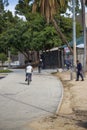 A man and a woman with their son riding bikes in the park near the playground wearing helmets surrounded by lush green trees