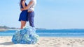 Man and woman together at the beach with blue flowers in-focus i