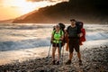 man and woman tourists on seashore against backdrop of sunset Royalty Free Stock Photo