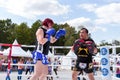 A man and a woman train in a Boxing ring. Thai kickboxing