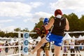 A man and a woman train in a Boxing ring. Thai kickboxing