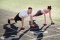 Man and a woman train with dumbbells at the stadium in the summer. Sports lifestyle. Royalty Free Stock Photo