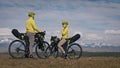The man and woman travel on mixed terrain cycle touring with bikepacking. The love couple journey with tent in with Royalty Free Stock Photo