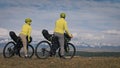 The man and woman travel on mixed terrain cycle touring with bikepacking. The love couple journey with tent in with