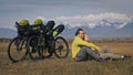 The man and woman travel on mixed terrain cycle touring with bikepacking. The two people journey with bicycle bags