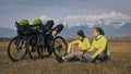 The man and woman travel on mixed terrain cycle touring with bikepacking. The two people journey with bicycle bags