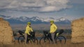 The man and woman travel on mixed terrain cycle touring with bikepacking. The two people journey with bicycle bags