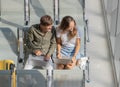 Man and woman travelers holding laptop notebook computer sitting together and wait for flight at airport lobby Royalty Free Stock Photo