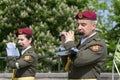 Man and woman in Ukrainian army uniform playing flutes during meeting devoted to Remembrance Day, municipal city park