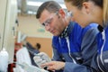 man and woman in uniform working with technical objet