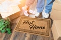 Man and Woman Unpacking Near First Home Welcome Mat, Moving Boxes and Plant Royalty Free Stock Photo