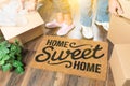 Man and Woman Unpacking Near Home Sweet Home Welcome Mat, Moving