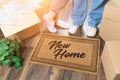 Man and Woman Unpacking Near New Home Welcome Mat, Moving Boxes and Plant Royalty Free Stock Photo