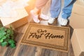 Man and Woman Unpacking Near Our First Home Welcome Mat, Moving Boxes and Plant Royalty Free Stock Photo