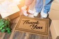 Man and Woman Unpacking Near Thank You Doo Mat, Moving Boxes and Plant Royalty Free Stock Photo