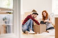 Man and woman unpacking stuff after relocation to new home