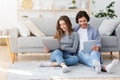 Man and woman using gadgets while spending weekend at home Royalty Free Stock Photo