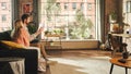 Man and Woman Using Tablet While Sitting on a Couch in a Stylish Apartment. A Young Couple Calling Royalty Free Stock Photo