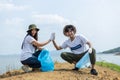 Man and woman volunteers cheerful hand touch high five holding rubbish bags. clean up garbage in tourist attractions. Conservation