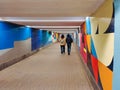 A man and a woman walk along an underground passage with painted walls. Rear view in perspective Royalty Free Stock Photo