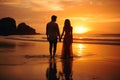 A man and a woman walk hand-in-hand on the sandy beach, bathed in the warm hues of a breathtaking sunset, couple on the beach at Royalty Free Stock Photo